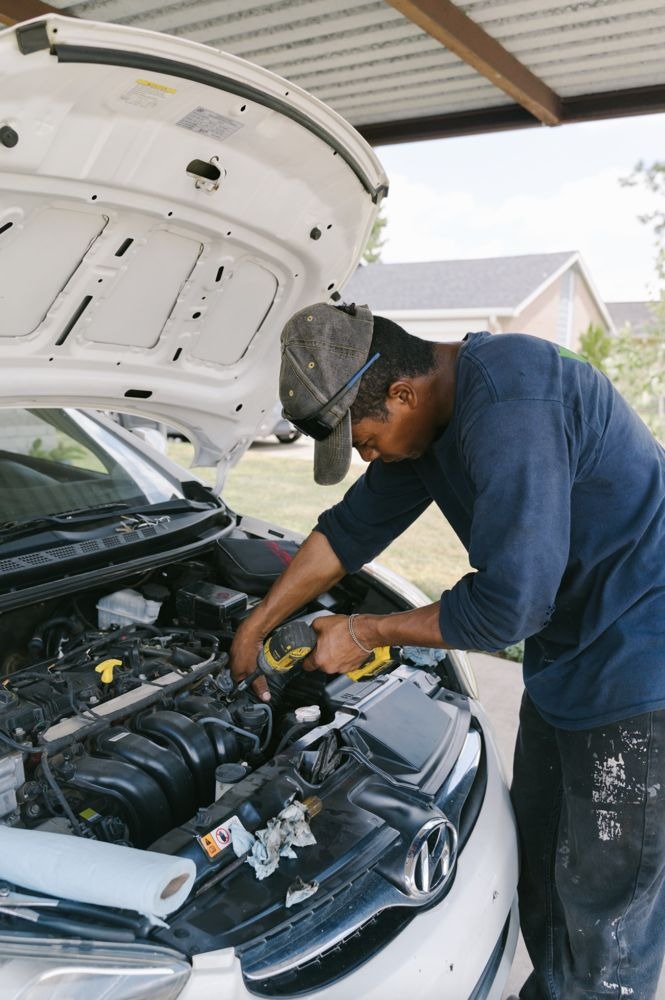 Westminster mobile mechanic working under the hood at a customer carport